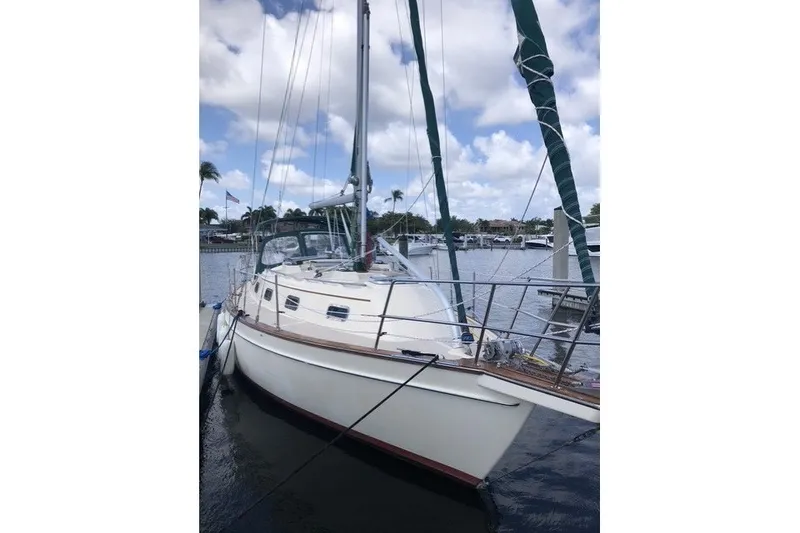 Slide: The Image of 2000 Island Packet 320 sailboat docked in a marina under a partly cloudy sky. - 4
