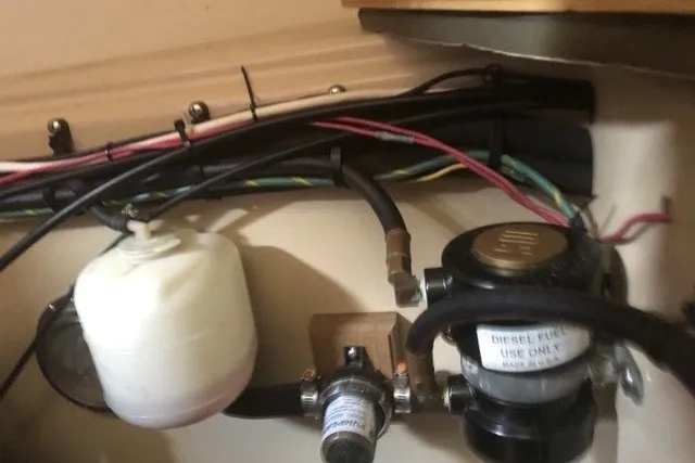 Slide: The Image of Engine compartment of a 2000 Island Packet 320 sailboat, showing fuel system components and wiring. - 96