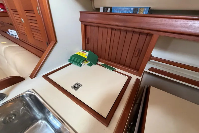 Slide: The Image of Interior of a 2000 Island Packet 320 sailboat with wooden cabinetry and kitchen sink. - 57
