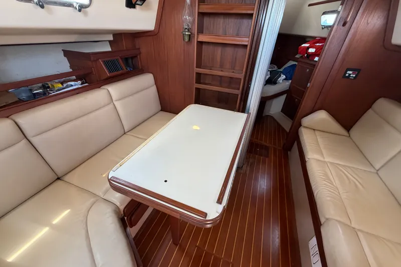 Slide: The Image of Interior of 2000 Island Packet 320 sailboat with beige seating and wooden accents. - 65