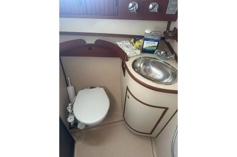 Slide: The Image of Compact bathroom in a 2000 Island Packet 320 yacht, featuring a toilet and stainless steel sink. - 93