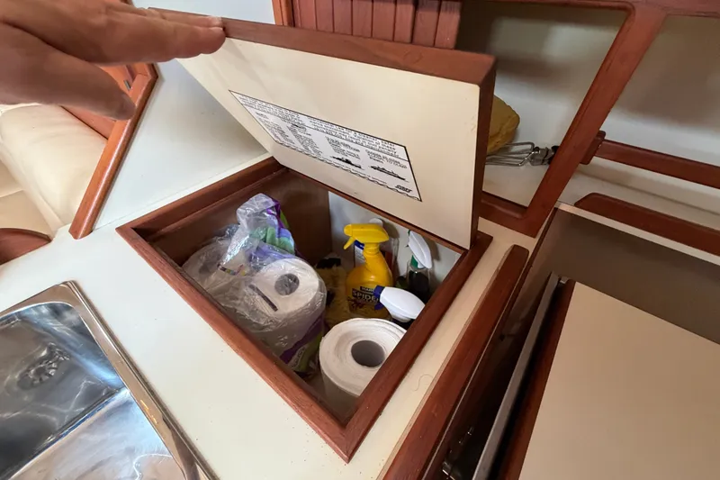 Slide: The Image of Storage compartment in 2000 Island Packet 320 yacht with cleaning supplies and paper towels. - 55