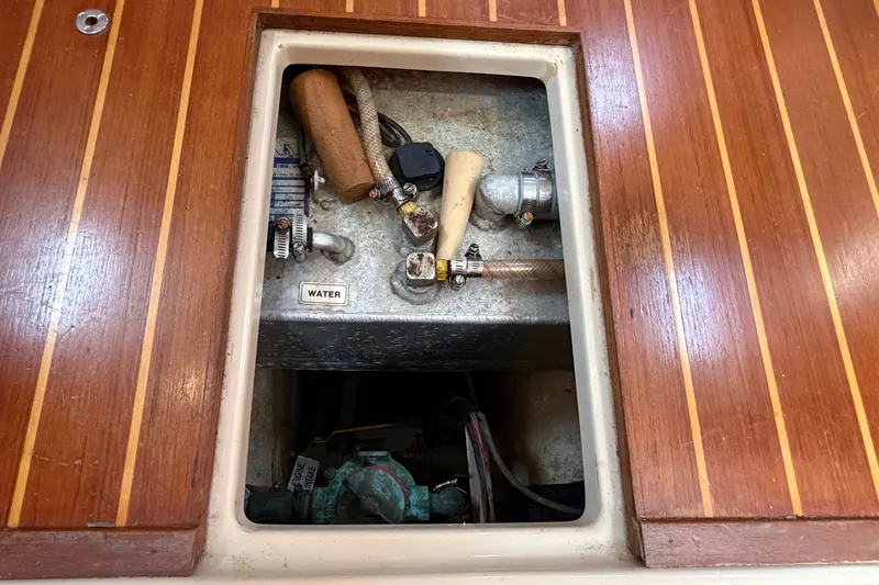 Slide: The Image of Access panel on Island Packet 320 sailboat, revealing water system components, 2000 model. - 78