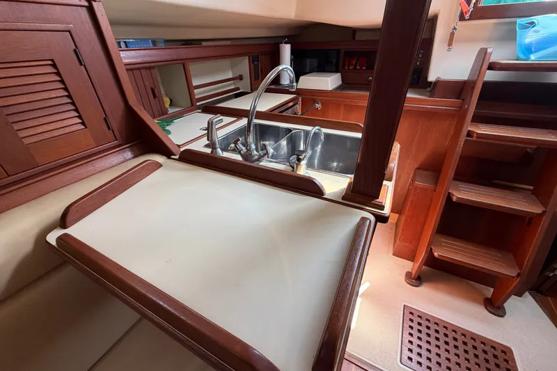 Slide: The Image of Interior of 2000 Island Packet 320 sailboat featuring a compact kitchen area. - 61