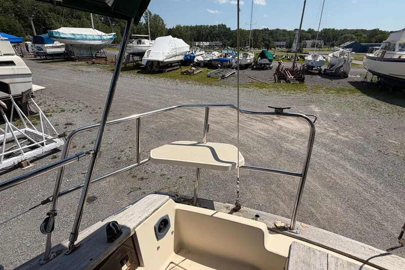 Slide: The Image of Island Packet 320 sailboat stern view in a boatyard, surrounded by other vessels. - 37