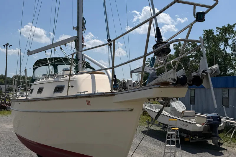 Slide: The Image of 2000 Island Packet 320 sailboat on land, with clear sky and surrounding boats. - 17