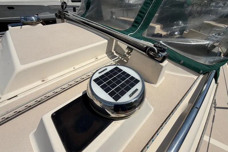Slide: The Image of 2000 Island Packet 320 sailboat deck with solar-powered vent and green canvas cover. - 30