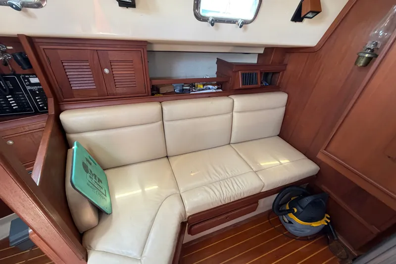Slide: The Image of Interior of a 2000 Island Packet 320 sailboat with cream leather seating and wooden cabinetry. - 62