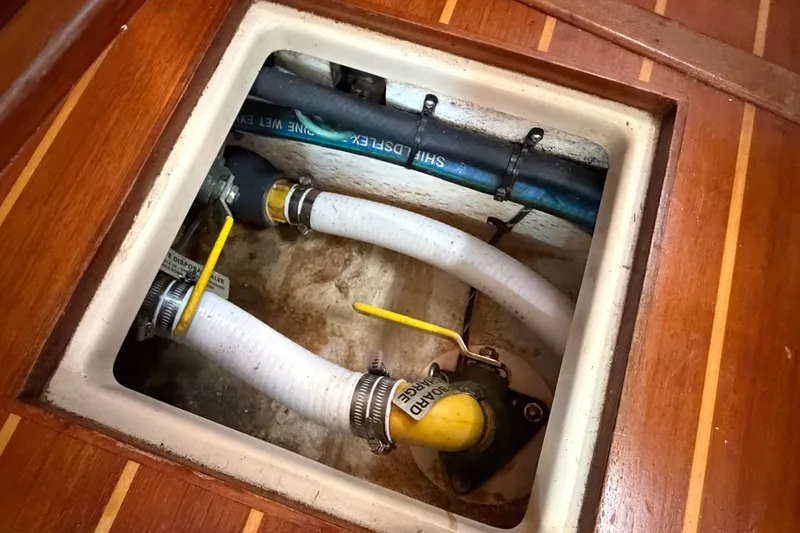 Slide: The Image of Bilge compartment of 2000 Island Packet 320 sailboat with hoses and valves. - 79