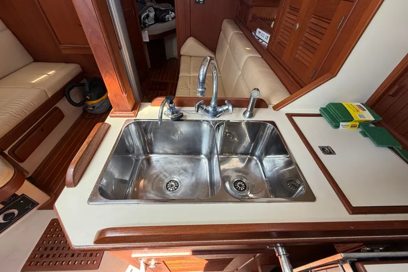Slide: The Image of Island Packet 320 yacht kitchen sink, dual basins, wooden cabinetry, 2000 model interior view. - 53