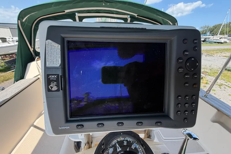 Slide: The Image of Garmin GPS device on 2000 Island Packet 320 sailboat, with compass and green canopy visible. - 36