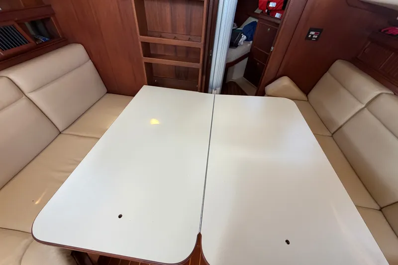 Slide: The Image of Interior of 2000 Island Packet 320 sailboat with beige seating and white table. - 66