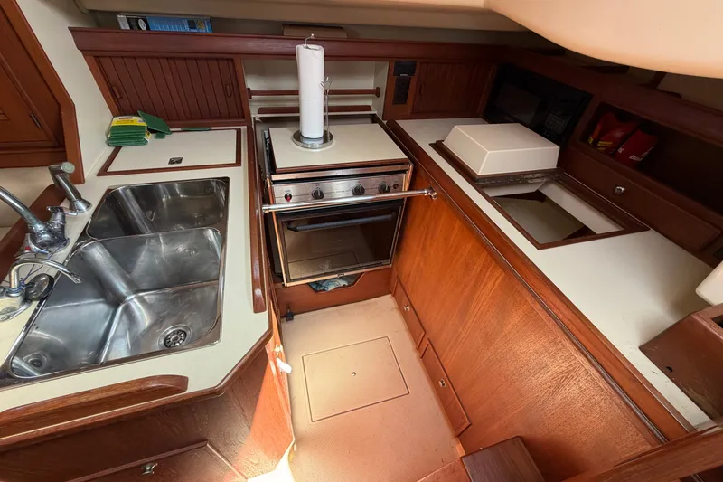Slide: The Image of Island Packet 320 yacht kitchen, 2000 model, featuring stainless steel sink and stove. - 54