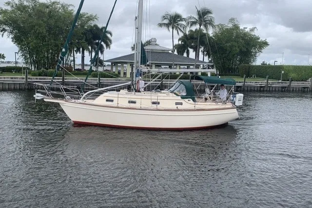 Slide: The Image of 2000 Island Packet 320 sailboat on a calm waterway, surrounded by lush greenery. - 2
