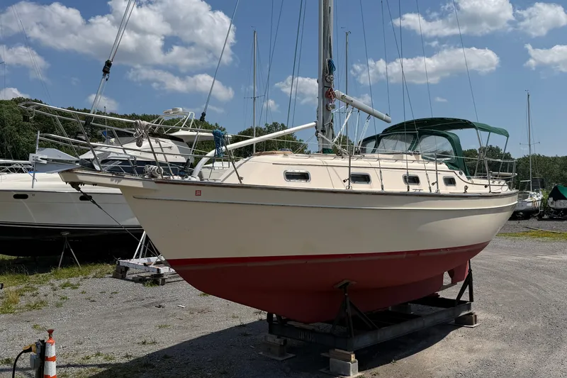 Slide: The Image of 2000 Island Packet 320 sailboat on dry dock under a clear blue sky. - 11