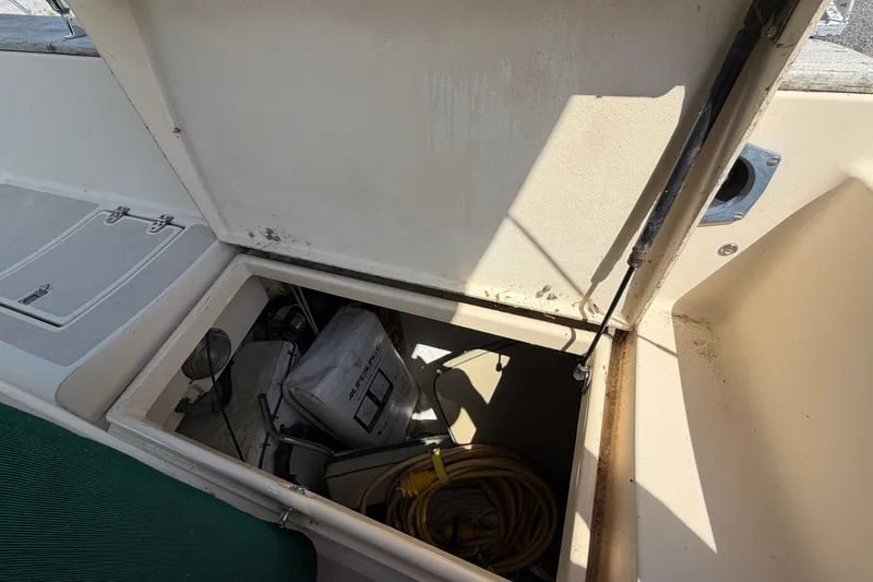 Slide: The Image of Open storage compartment on a 2000 Island Packet 320 sailboat, revealing equipment and cables. - 44