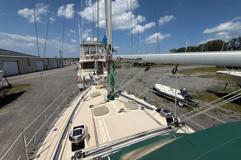 Slide: The Image of 2000 Island Packet 320 sailboat on land, with clear sky and marina background. - 23