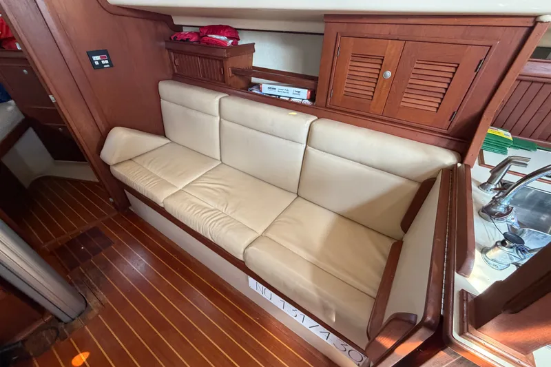 Slide: The Image of Interior of 2000 Island Packet 320 sailboat with beige seating and wooden cabinetry. - 63