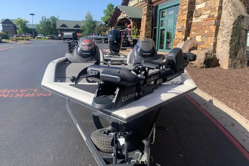 Slide: The Image of 2018 Tracker Pro Team 195 TXW boat with Garmin equipment, parked outside a rustic building. - 6