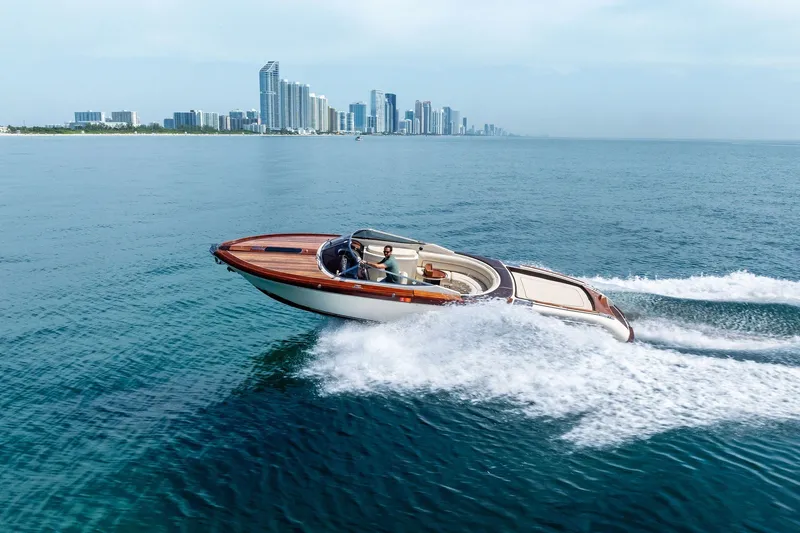 Slide: The Image of 2006 Riva 33' Aquariva speedboat cruising near a city skyline on a clear day. - 6