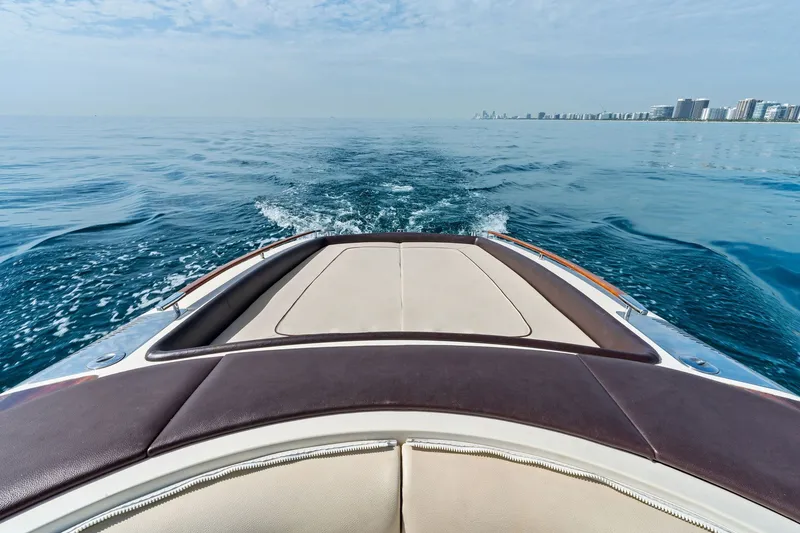 Slide: The Image of 2006 Riva 33' Aquariva cruising on calm ocean waters with city skyline in the distance. - 9