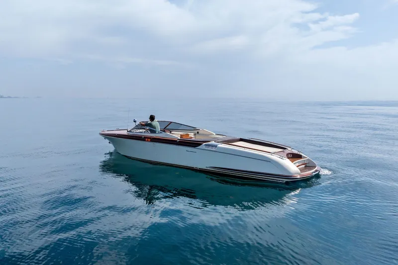 Slide: The Image of 2006 Riva 33' Aquariva boat cruising on calm, clear blue water under a cloudy sky. - 3