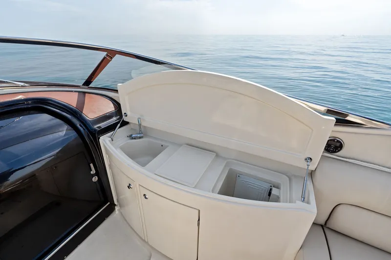 Slide: The Image of 2006 Riva 33' Aquariva yacht interior with open storage compartment and ocean view. - 17
