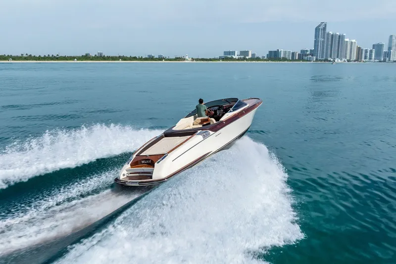 Slide: The Image of 2006 Riva 33' Aquariva cruising on blue waters near a city skyline. - 7
