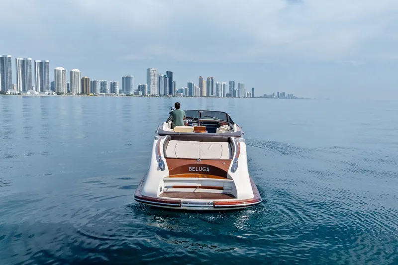 Slide: The Image of Luxury 2006 Riva 33' Aquariva yacht cruising near city skyline. - 2