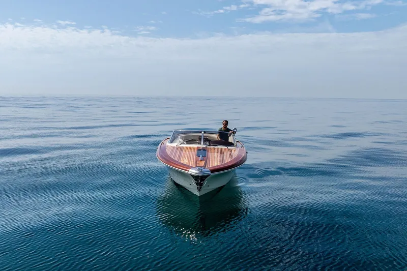 Slide: The Image of 2006 Riva 33' Aquariva boat cruising on calm, open water under a clear sky. - 5