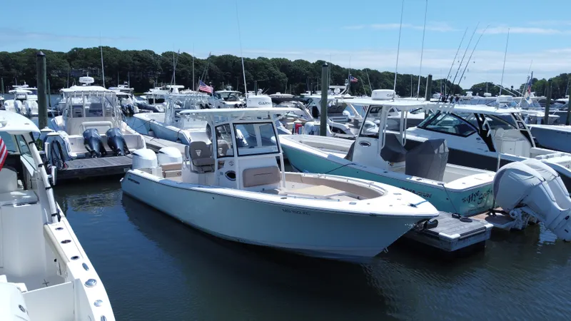 The Image of A 2019 Sportsman Open 282 Center Console boat docked in a busy marina. - 0