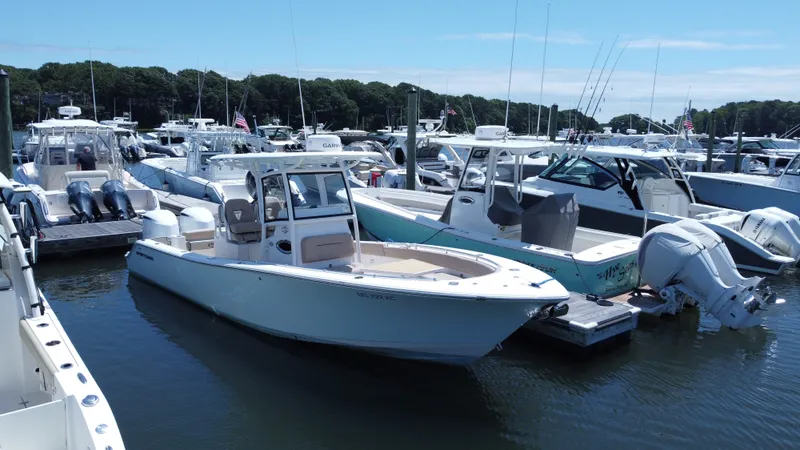 Slide: The Image of A 2019 Sportsman Open 282 Center Console is docked in a busy marina. - 1