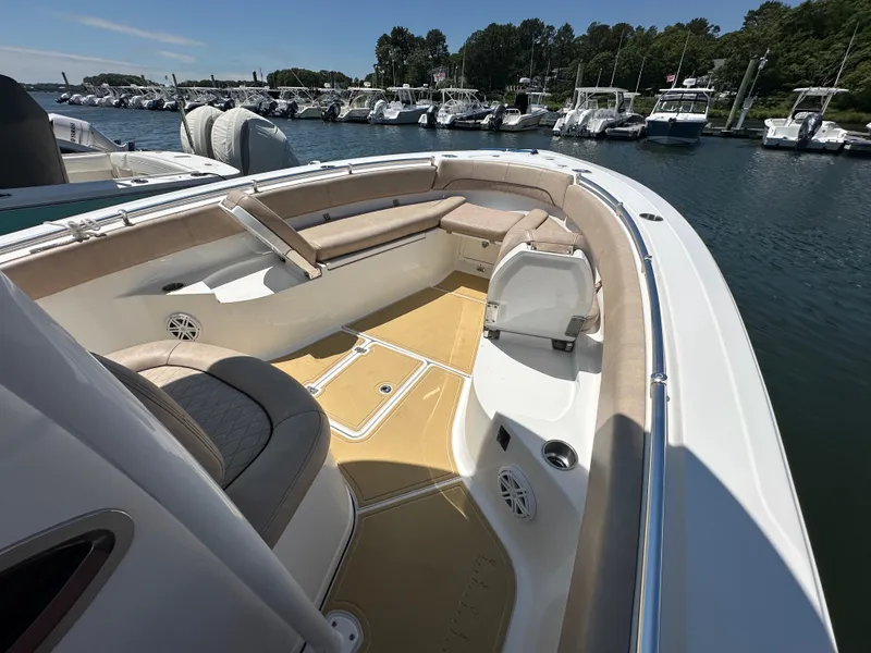 Slide: The Image of The image shows the bow of a 2019 Sportsman Open 282 Center Console boat docked at a marina. - 12