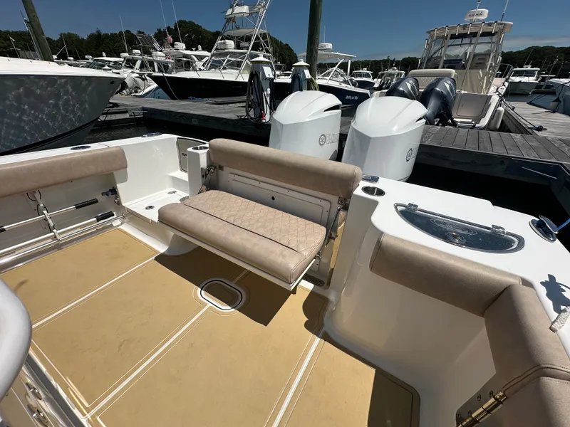 Slide: The Image of The image shows the cockpit of a 2019 Sportsman Open 282 Center Console boat with beige seating. - 24