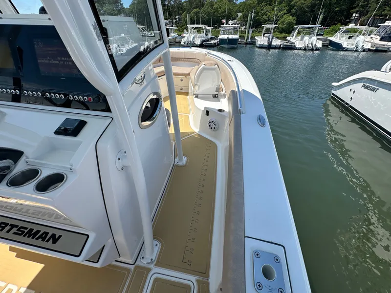Slide: The Image of The image shows a 2019 Sportsman Open 282 Center Console boat on the water. It features a spacious deck and modern electronics. - 19