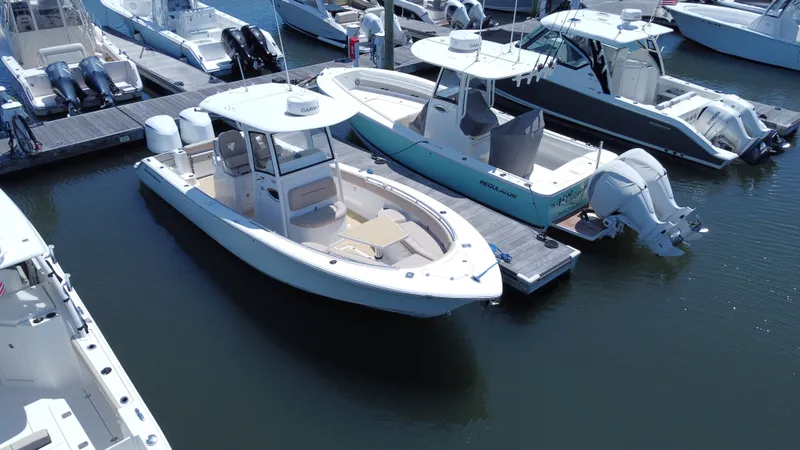 Slide: The Image of A 2019 Sportsman Open 282 Center Console boat docked, surrounded by other boats. - 2
