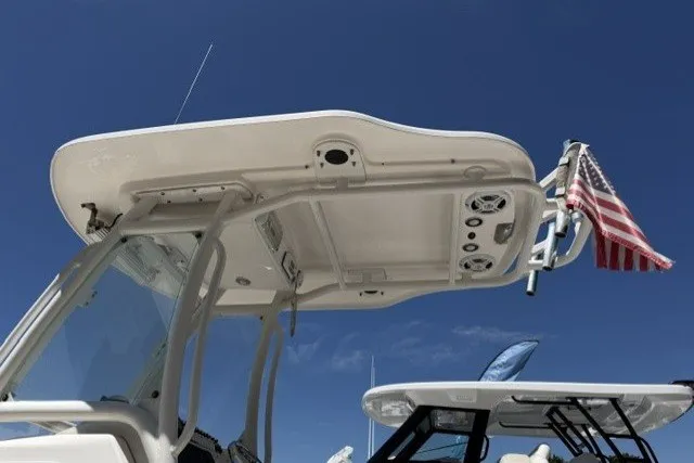 Slide: The Image of 2013 Everglades 210 Center Console boat with T-top and American flag against blue sky. - 6