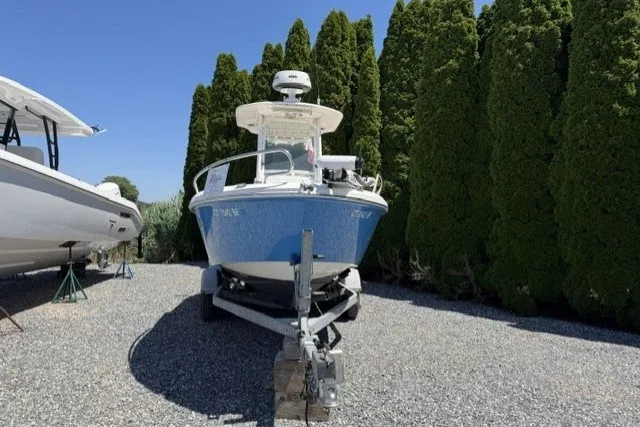 Slide: The Image of 2013 Everglades 210 Center Console boat on trailer, parked outdoors near tall trees. - 2