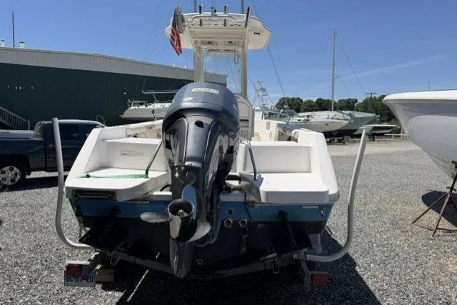 Slide: The Image of 2013 Everglades 210 Center Console boat with outboard motor, parked in a marina. - 3
