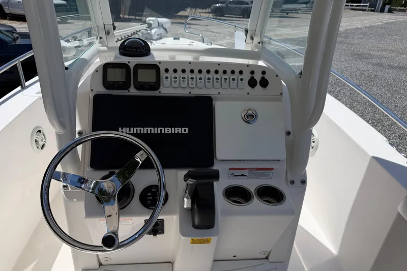 Slide: The Image of 2013 Everglades 210 Center Console boat dashboard with steering wheel and Humminbird display. - 16