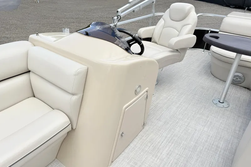 Slide: The Image of Luxurious interior of 2019 South Bay 520CR pontoon boat with plush seating and steering console. - 8