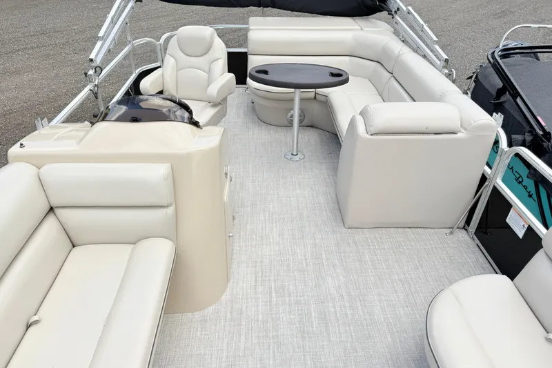 Slide: The Image of 2019 South Bay 520CR pontoon boat interior with beige seating and round table. - 5