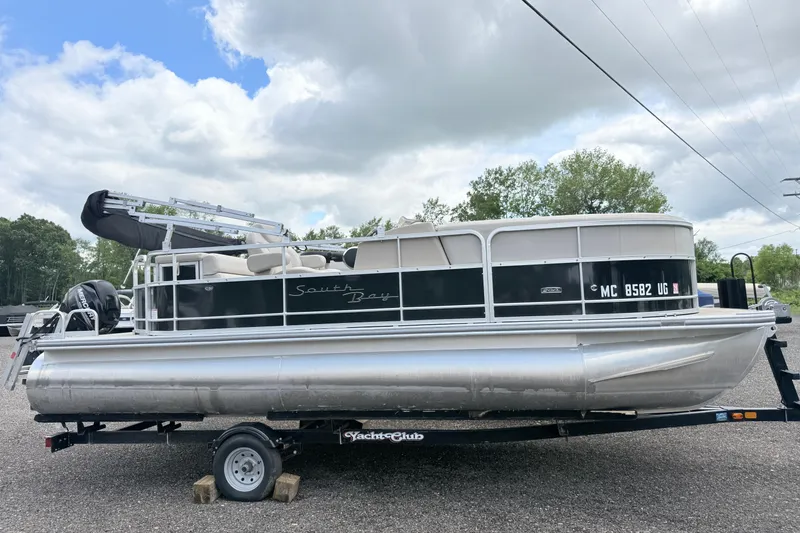 The Image of 2019 South Bay 520CR pontoon boat on trailer under cloudy sky. - 0