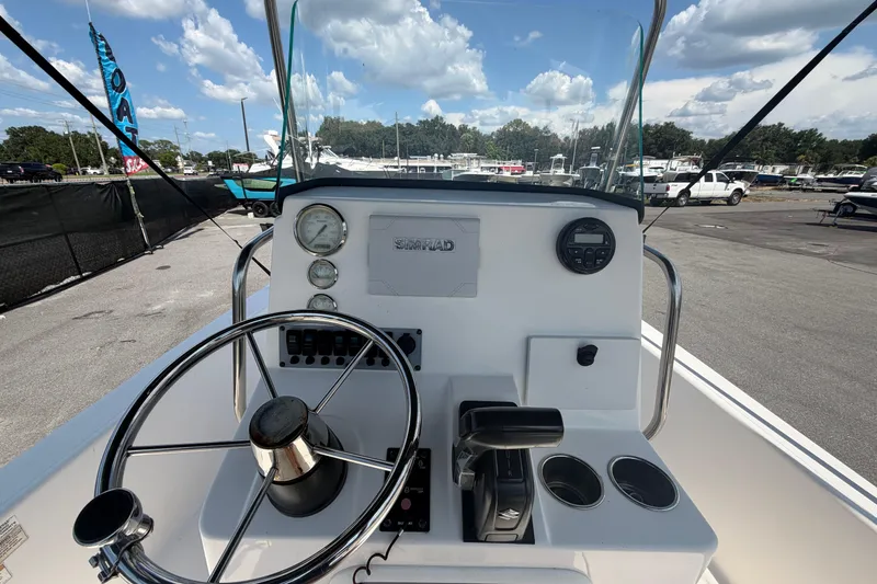 Slide: The Image of 2019 Sea Born SV19 Bay boat dashboard with steering wheel and controls under a clear sky. - 15