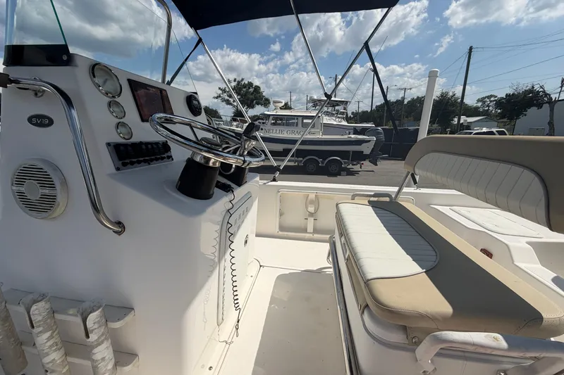 Slide: The Image of 2019 Sea Born SV19 Bay boat interior with steering wheel and seating under blue sky. - 22