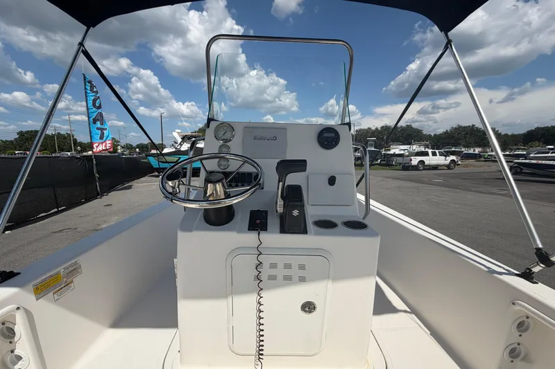 Slide: The Image of 2019 Sea Born SV19 Bay boat console with steering wheel and controls under a sunny sky. - 12