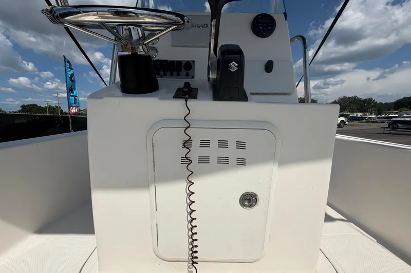 Slide: The Image of 2019 Sea Born SV19 Bay boat console with steering wheel and controls under a cloudy sky. - 13