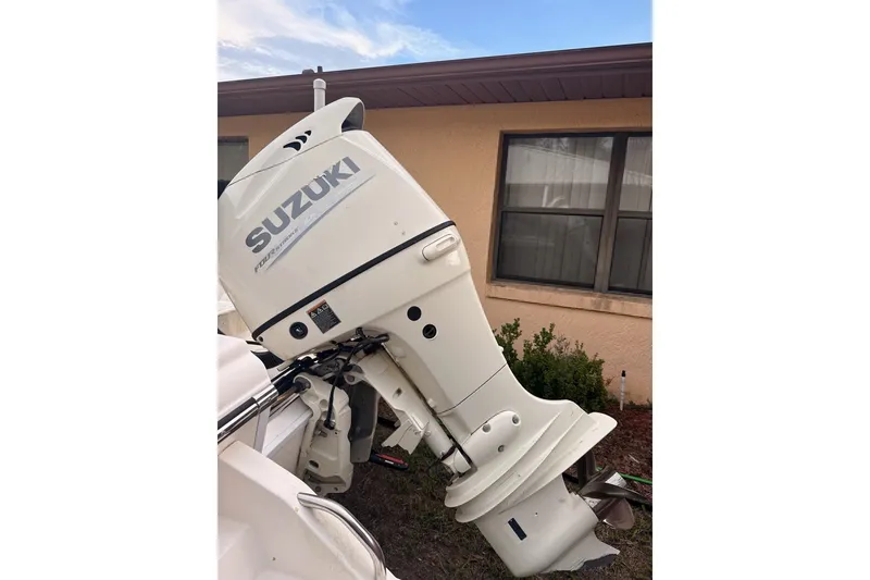 Slide: The Image of 2019 Sea Born SV19 Bay with Suzuki outboard motor, parked near a house. - 3