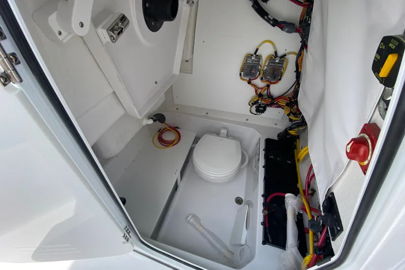 Slide: The Image of Interior of 2027 Sportsman Heritage 231 Center Console boat, featuring wiring and marine toilet. - 34