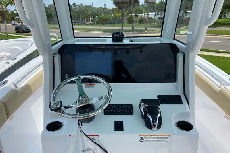 Slide: The Image of 2027 Sportsman Heritage 231 Center Console boat dashboard with steering wheel and controls. - 16
